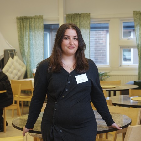 Kvinna i lokal med fikabord